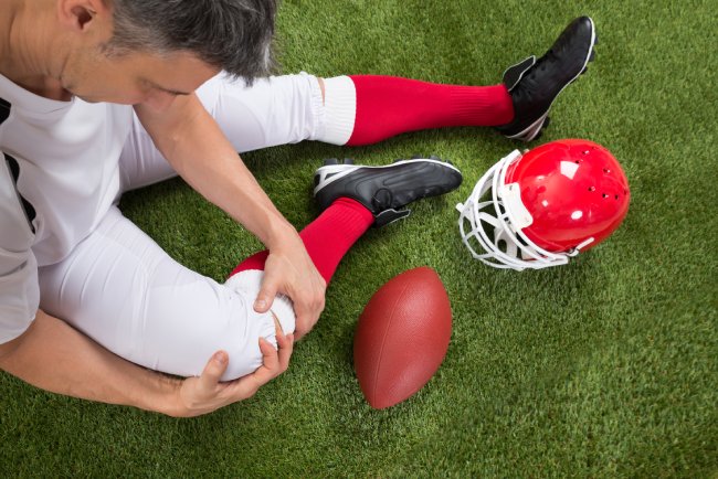 Close-up Of A American Football Player With Injury In Leg On Field