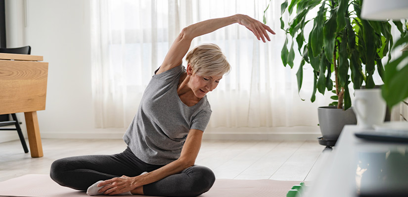 A woman performs yoga in her living room, focusing on overcoming chronic pain in the Texas heat.