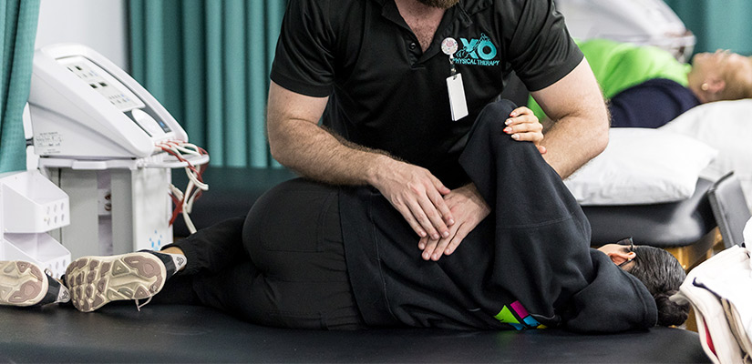 XO physical therapy in South Texas facility. A man guides a patient through non-surgical spinal decompression therapy during a physical therapy session.