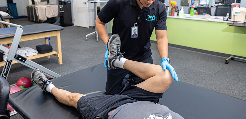 A man receives a leg examination in XO Therapy facility, highlighting expert physical therapy advice for South Texas runners.