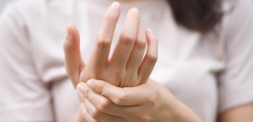 A woman with her hands on her hands, demonstrating techniques for alleviating arthritis discomfort in stiff joints.
