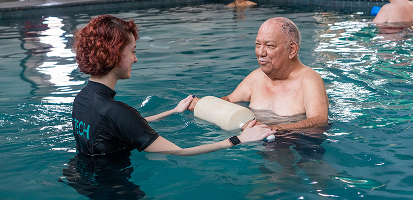 A man and woman assist an older man in a pool, highlighting fall relief techniques for arthritis and stiff joints.