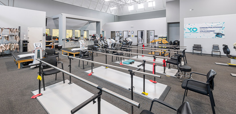 A spacious XO facilities for physical therapy showcasing multiple exercise machines, highlighting physical therapy's role in reducing holiday-related pain.