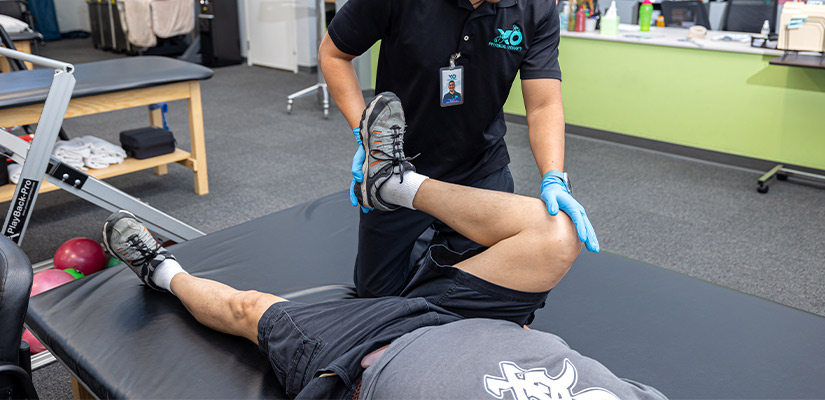 A physical therapist assists a man with an exercise aimed at pain management in Mission, TX.