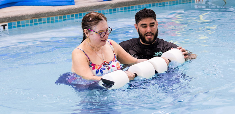 A man and woman engage in pool therapy with a white ball, promoting pain management techniques in McAllen.