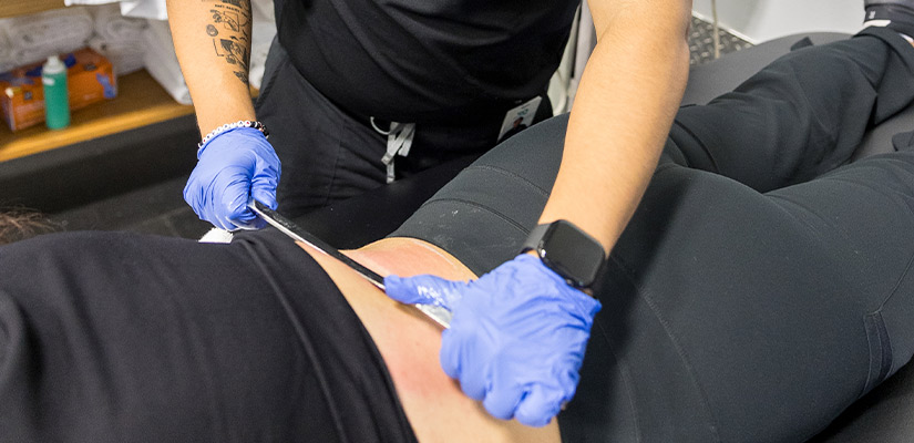 A woman undergoing surgery with an incision on her abdomen, focused on addressing her back pain relief needs.